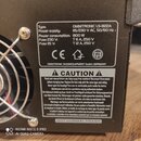 Fotografie detailu štítku na zadní straně černého elektronického zařízení. Na štítku je uveden typ OMNITRONIC LS-822A, Power supply: 115/230 V AC, 50…