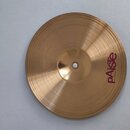 Kruhový činel z mosazného kovu s jemným rýhováním. Na povrchu je vpravo viditelné červené logo Paiste a pod ním menší nápis MADE IN SWITZERLAND. Povr…