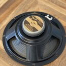 Černý reproduktor s kovovým rámem a papírovou membránou. Uprostřed je štítkem s nápisy „Fender“, „SPECIALLY DESIGNED FOR FENDER INSTRUMENTS CORPORATI…