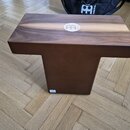 Hnědý dřevěný cajón s logem MEINL v bílém kruhu na horní hraně. Nástroj má kompaktní tvar s vyčnívající horní deskou a užším spodním tělem. Povrch dř…