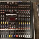 Černý mixovací pult s kovovým rámem a mnoha ovládacími prvky. Na předním panelu je bílý nápis „DYNACORD CMS 2200 COMPACT MIXING SYSTEM“. Zařízení obs…