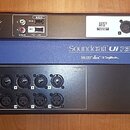 Černý rackový digitální mixážní pult s modrým prostředním panelem. Na modrém panelu je bílý nápis Soundcraft Ui 16 a pod ním menší loga lexicon, dbx…