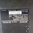 Fotografie detailu černého štítku na zadní straně reproduktoru. Štítek obsahuje bílý nápis SONY, MODEL NO. SS-SR300 a označení SPEAKER SYSTEM. Jsou z…