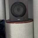 Studiový monitor v tmavě hnědém dřevěném provedení. Na spodní hraně je bílý nápis FOCAL a vedle něj svítí malá zelená kontrolka. Reproduktor má černo…