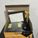 Kartonová krabice s obsahem, který zahrnuje černé elektronické zařízení v plastovém obalu a černý ovladač. Na krabici je nápis BEAMZLIGHTING.COM a lo…