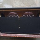Zadní strana černého kytarového komba s obalením z vinylu a kovovými rohy. Spodní část zadního panelu je zakrytá černou deskou s jedním centrálním ko…