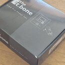 Černá kartonová krabice s nápisy „the t.bone“ a „GigA Pro Pedal Set“. Na horní straně je bílá črtné znázornění pedálu a napájecího adaptéru. Krabice…