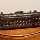 Zadní strana černého mixážního pultu s kovovým šasi a perforovaným horním krytem. Jsou zde viditelné nápisy USB, MADE IN CHINA, MONITOR OUT (A, B), R…