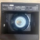 Zadní strana kytarového komba v černém provedení s otevřeným zadním panelem, skrze který je vidět reproduktor. Na středovém krytu reproduktoru je log…
