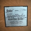 Kovový štítek s technickými údaji připevněný na dřevěný povrch. Na štítku je logo Leslie, nápis SERIAL J 17819 a označení SPEAKER MODEL 147. Dále je…