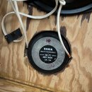 Fotografie zachycuje malý reproduktor osazený v dřevěné desce z překližky. Na šedém štítku reproduktoru je nápis TESLA, MADE IN CZECHOSLOVAKIA, Hi-Fi…