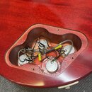 Fotografie zachycuje otevřenou elektronickou dutinu v červeném trupu elektrické kytary. Uvnitř jsou vidět čtyři potenciometry s kovovými kryty a něko…