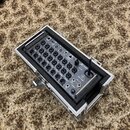 Digitální mixážní pult v hliníkovém transportním kufru s černým polstrováním. Na zařízení jsou viditelná loga X AIR a behringer, dále nápis XR18. Zad…