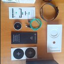 Sada příslušenství Soundbrenner Pulse v originálním balení. Na fotografii je černý vibrační metronom s řemínkem, nabíjecí kabel v tyrkysové barvě a m…