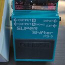 Modře barevný efekt pedál s černým spínacím tlačítkem a třemi ovládacími knoflíky. Na zařízení jsou nápisy SUPER Shifter PS-5 a logo BOSS. Horní pane…