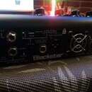 Záběr na zadní panel černého kytarového zesilovače značky Blackstar. Jsou vidět různé konektory s popisky OUT L, FX LOOP SEND, RETURN LEVEL (+4dBu a…