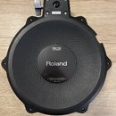 Černý elektronický bicí pad s nápisy Roland a PDX-100 DUAL TRIGGER PAD. Ve spodní části je text For use under one or more of U.S. Pat. Nos. 5,329,018…
