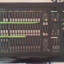 Černý světelný kontrolér s nápisem SCM Studio 24 professional light controller. Zařízení obsahuje množství posuvníků, tlačítek a několik otočných pot…