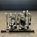 Stříbrný kovový bicí pedál s černými plošinkami a černým řetězem. Na levé plošince je viditelný nápis IRON COBRA SUPER. Součástí je černá spojovací t…
