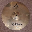 Zlatý kovový činel s viditelným logem Zildjian ve spodní části. V horní části je logo s nápisem CUSTOM a textem HIHAT TOP 14"/36 cm. Na pravém okraku…