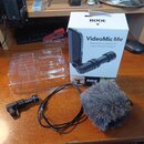 Na fotografii je mikrofon s příslušenstvím a originální krabicí. Na bílé krabici jsou nápisy RØDE MICROPHONES, VideoMic Me™, Directional microphone f…