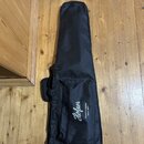 Černý textilní obal na hudební nástroj s úchytmi a přední kapsou. Na kapse je bílý nápis „Höfner Guitars & Basses -since 1887-“. Povrch materiálu je…