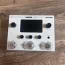 Bílý efektový procesor Hotone Ampero Stomp. Na horní hraně je nápis AMPERO STOMP, CDCM HD Gen 2 Amp Modeler / Effects Processor a logo HOTONE. Zaříze…