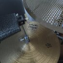 Detailní pohled na horní činelyl hi-hat z mosazi s viditelným rýhováním povrchu. Na činelylu je logo PAISTE a nápis Twenty, dále text TRADE MARK MADE…