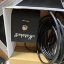 Černý čtvercový spínací pedál s bílým nápisem Marshall a označením Channel nad stříbrným tlačítkem. K pedálu je připojený černý kabel, který je sbale…