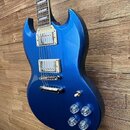 Modrá elektrická kytara s charakteristickým SG tvarem korpusu a hnedým hmatníkem. Nástroj má dva humbuckery s krémovými rámečky, chromovaný kobylník…