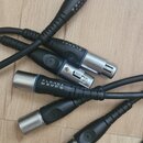 Fotografie zobrazuje šest konců černých kabelů s kovovými konektory. Na dvou z nich je viditelný bílý nápis planet waves. Konektory jsou v kombinaci…