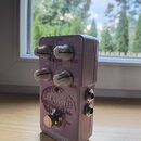 Světle fialový efekt pedál s nápisy BRAINWAVES a PITCH SHIFTER. Na spodní části je logo tc electronic a nápis TRUE BYPASS. Zařízení má čtyři bílé oto…