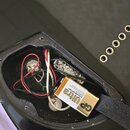 Fotografie zachycuje otevřený přístupový otvor v černé lakované dřevěné kostře nástroje. Uvnitř jsou vidět elektrické spoje, červené a bílé vodiče a…