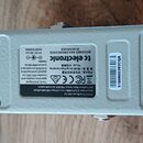 Fotografie zachycuje spodní stranu stříbrného efekt pedálu z kovu. Na spodní části je černý štítek s nápisy „tc electronic“, „DESIGNED AND ENGINEERED…