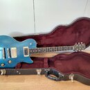 Modrá elektrická kytara typu Les Paul v tvrdém kufru s červeným plyšovým vnitřkem. Na hlavě kytary je bílý nápis SUMMIT CLASSIC a logo výrobce. Nástr…