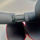 Detailní pohled na černý plastový prvek, pravděpodobně součásti sluchátek. Na povrchu jsou viditelné nápisy Model B0501, S/N:FL4V40STG764 a písmeno R…