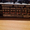 Zadní strana míchacího pultu v černé barvě s bílými nápisy. Na horní části je uveden název BEHRINGER® PRO MIXER VMX300 a webová adresa www.behringer.…
