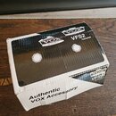 Kartonová krabice s černým potiskem, na které je vidět logo VOX AMPLIFICATION LTD. a označení VFS2 Footswitch. Na boční bílé straně je nápis Authenti…