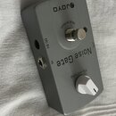Šedý efekt pedál s nápisy JOYO, Noise Gate a Threshold. Na horní části je stoupací spínač s označením TRUE BYPASS a bílý otočný knoflík. Na boku jsou…