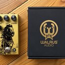Zlatý efekt pedál s černými ovládacími knoflíky a nápisy level, tone, distortion. Na spodní části je černý grafický obrázek koně a nápisy IRON HORSE…