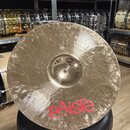 Zlatý kovový činel s viditelnou strukturou povrchu. V dolní části je červené logo Paiste. Nad středovým zvoncem je malý kulatý nápis, který je nečite…