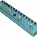 Tyrkysový efektový pedál s čtyřmi stomečovými spínači. Nad spínači jsou umístěny černé otočné knoflíky a nápisy A/REVERB, B/DELAY, C/MOD a D/AMP. Mez…