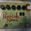 Světle zelený efekt pedál s ornamentálním vzorem a červeným nápisem Ravish Sitar. Na spodní části je černý nápis electro-harmonix a text MADE IN NYC,…