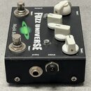 Černý efekt pedál s nápisy FUZZ UNIVERSE, Majjk Box, Thrust 1, Thrust 2, Input, Output a 9VDC. Na horní ploše jsou dva stříbrné spínače a čtyři bílé…