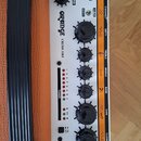 Ovládací panel kytarového komba v bílé barvě s oranžovými detaily. Je na něm uveden nápis ORANGE a model CRUSH 35RT. Panel obsahuje několik černých o…