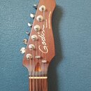 Hlava elektrické kytary z hnědého dřeva s chromovanými ladicími kolíky. Na povrchu je bílý nápis Godin, Stadium HT a Hand-crafted in Canada. Povrch d…