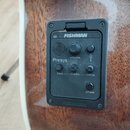Detail na předzesilovač s tunrem zabudovaný v hnědém dřevěném těle akustické kytary. Černý plastový panel nese nápisy FISHMAN, Presys, volume, bass,…