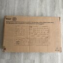 Kartonová krabice s černým potiskem znázorňujícím syntetizátor. V horní části je nápis POLY D a text Analog 4-Voice Polyphonic Synthesizer with 37 Fu…