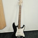 Černá elektrická kytara typu Stratocaster s bílým pickguardem a hnedým hmatníkem. Na hlavě nástroje je viditelné logo Squier. Kytara má tři snímače,…