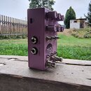 Fialový efekt pedál s nápisem MOOD. Na horní straně jsou čtyři ovládací knoflíky s popisky TIME, CRAMP, MODIFY a CLOCK. Na boku jsou dva konektory s…